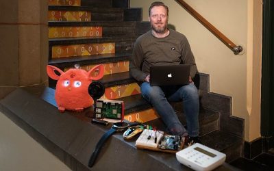 Erik Rutkens met macbook op trap, voorgrond slimme apparatuur